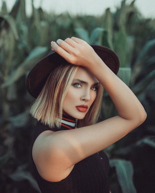 A Woman in Black Sleeveless Top Wearing a Black Hat