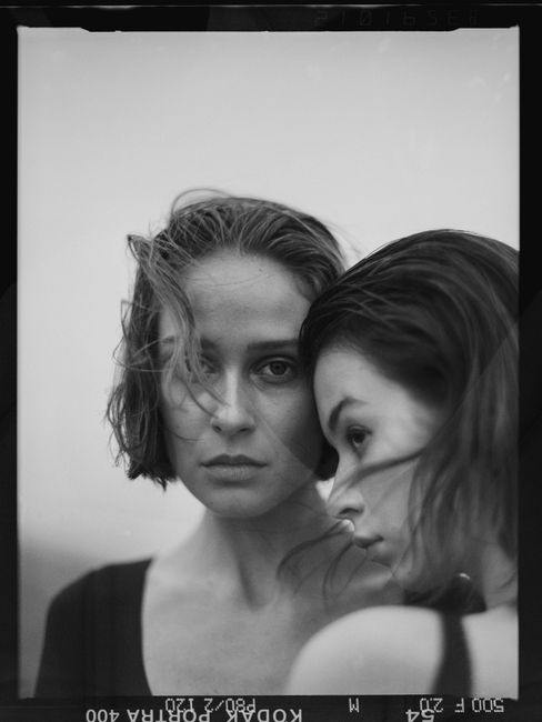 Artistic black and white portrait showcasing duo in an emotional pose.