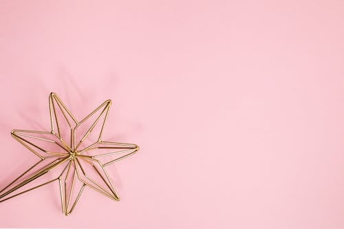 Free Gold Star Against a Pink Background Stock Photo
