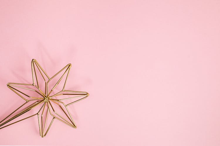 Gold Star Against A Pink Background