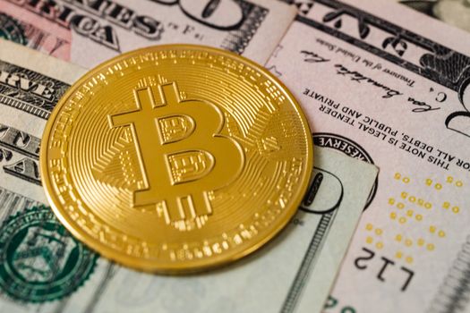一张比特币硬币置于美元纸币上的详细视图，象征着现代金融