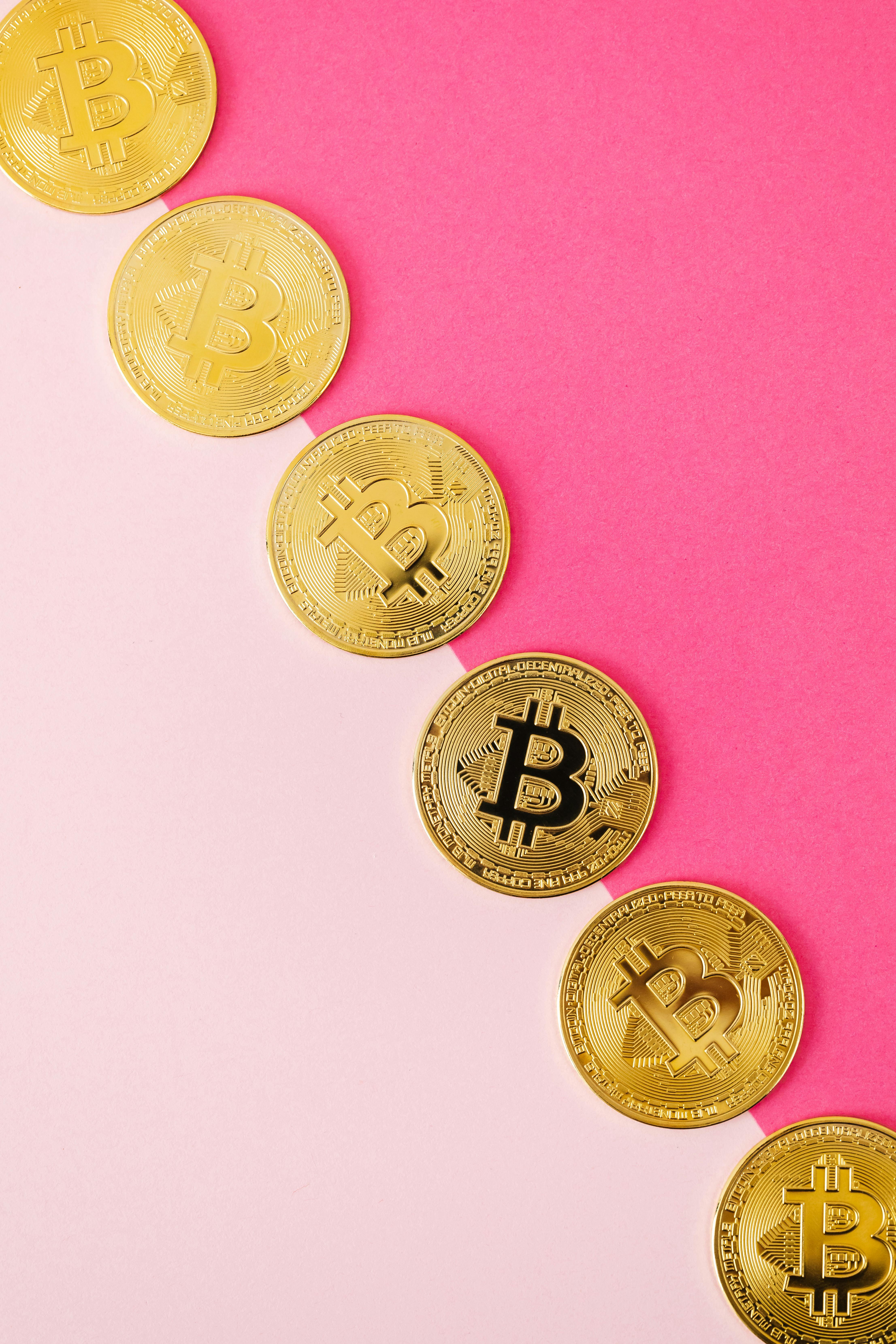 gold round coins on pink surface