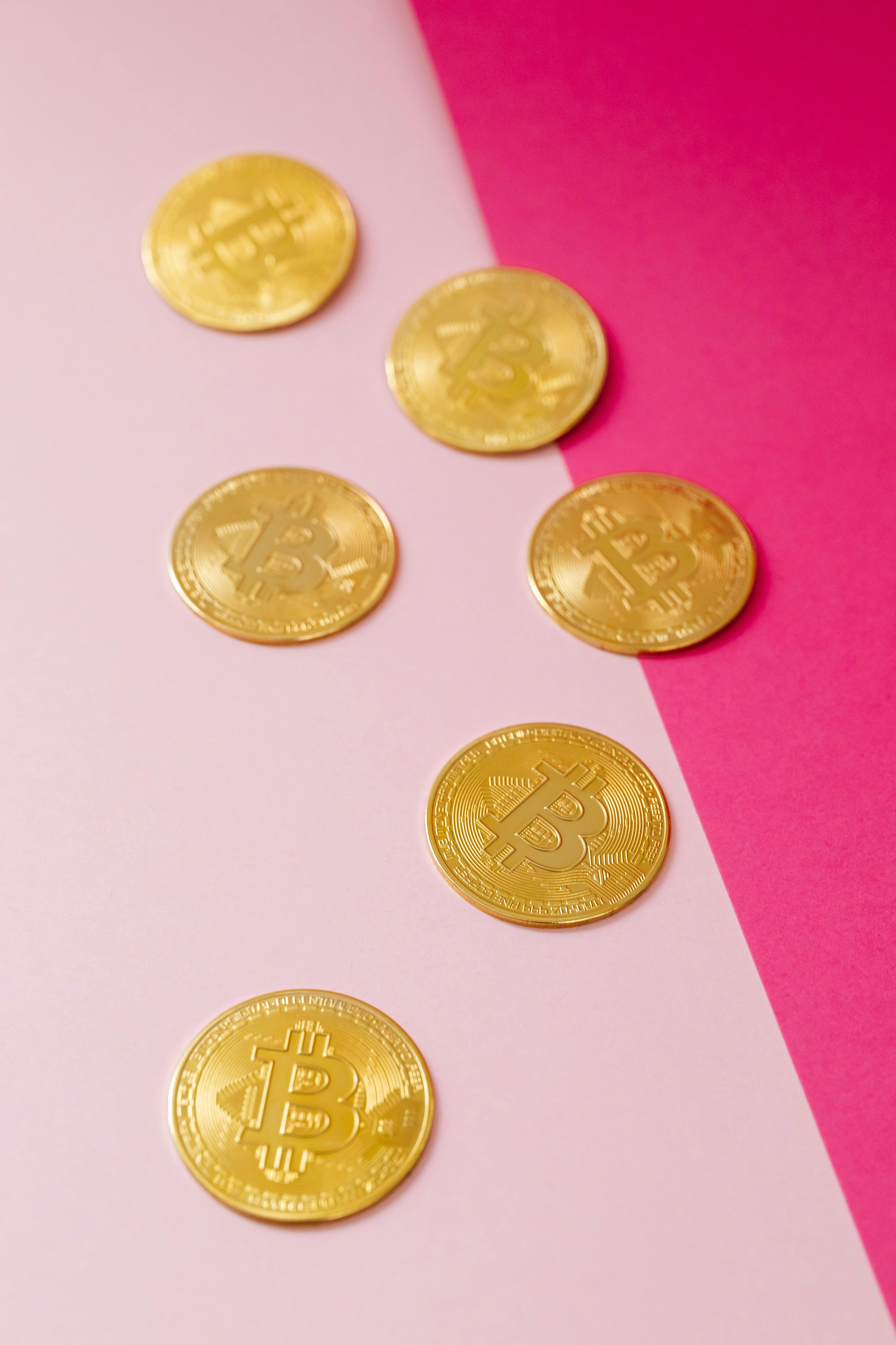 gold bitcoins on a pink background