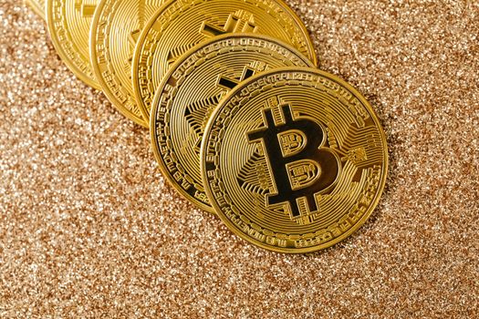 金色的比特币硬币在闪闪发光的表面排列，象征着加密货币与财富