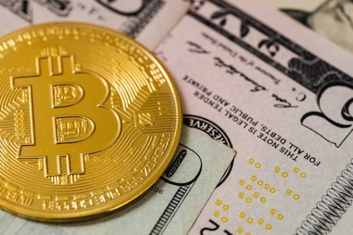 Close-up of a Gold Bitcoin Coin and Cash 