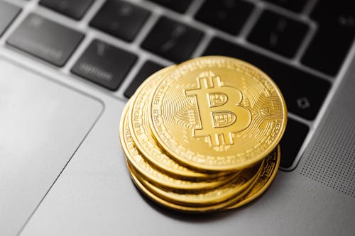 Close-Up Shot of Bitcoins on Laptop Computer