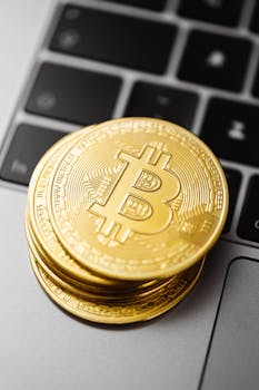 Close-up of golden Bitcoin coins stacked on a laptop keyboard showcasing cryptocurrency and finance concepts.