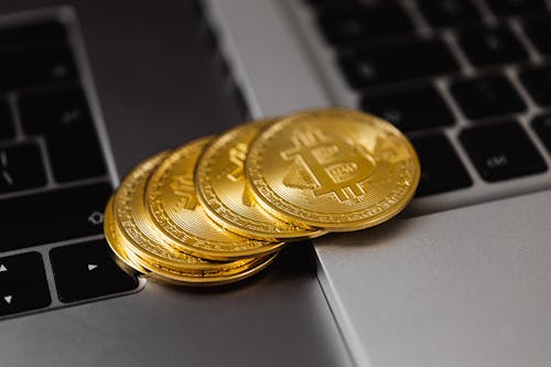 Close-Up Shot of Bitcoins on Laptop Computers