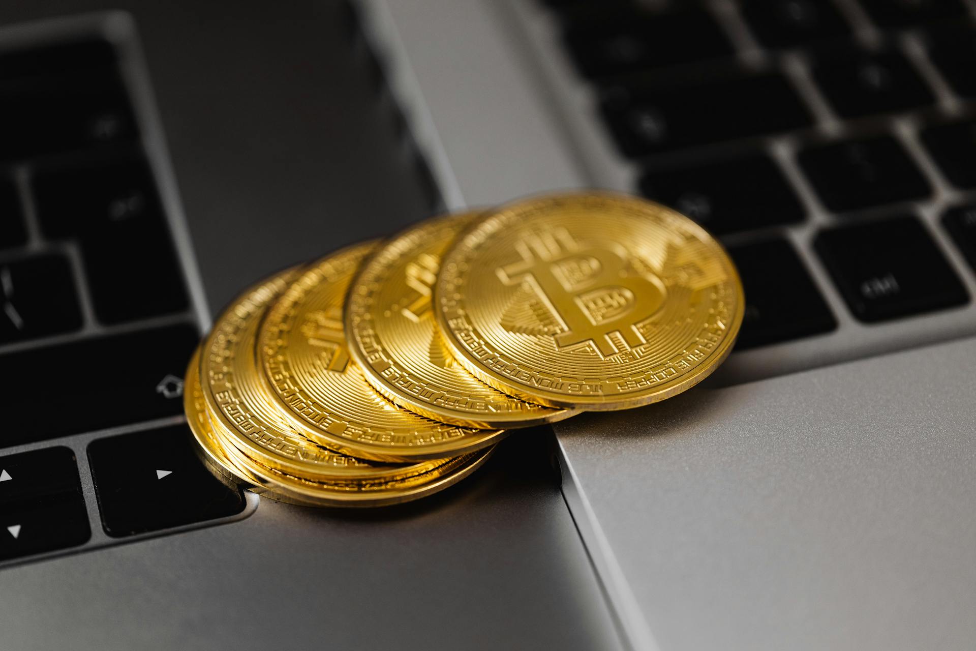 Close-Up Shot of Bitcoins on Laptop Computers