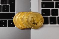 比特币特写放置在两个笔记本电脑键盘上，代表数字货币和技术