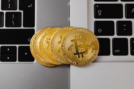 Close-up of Bitcoin coins resting on two laptop keyboards, representing digital currency and technology.