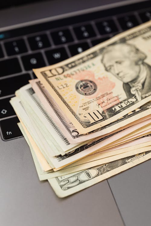 Free Dollar Bills on Top of a Laptop  Stock Photo