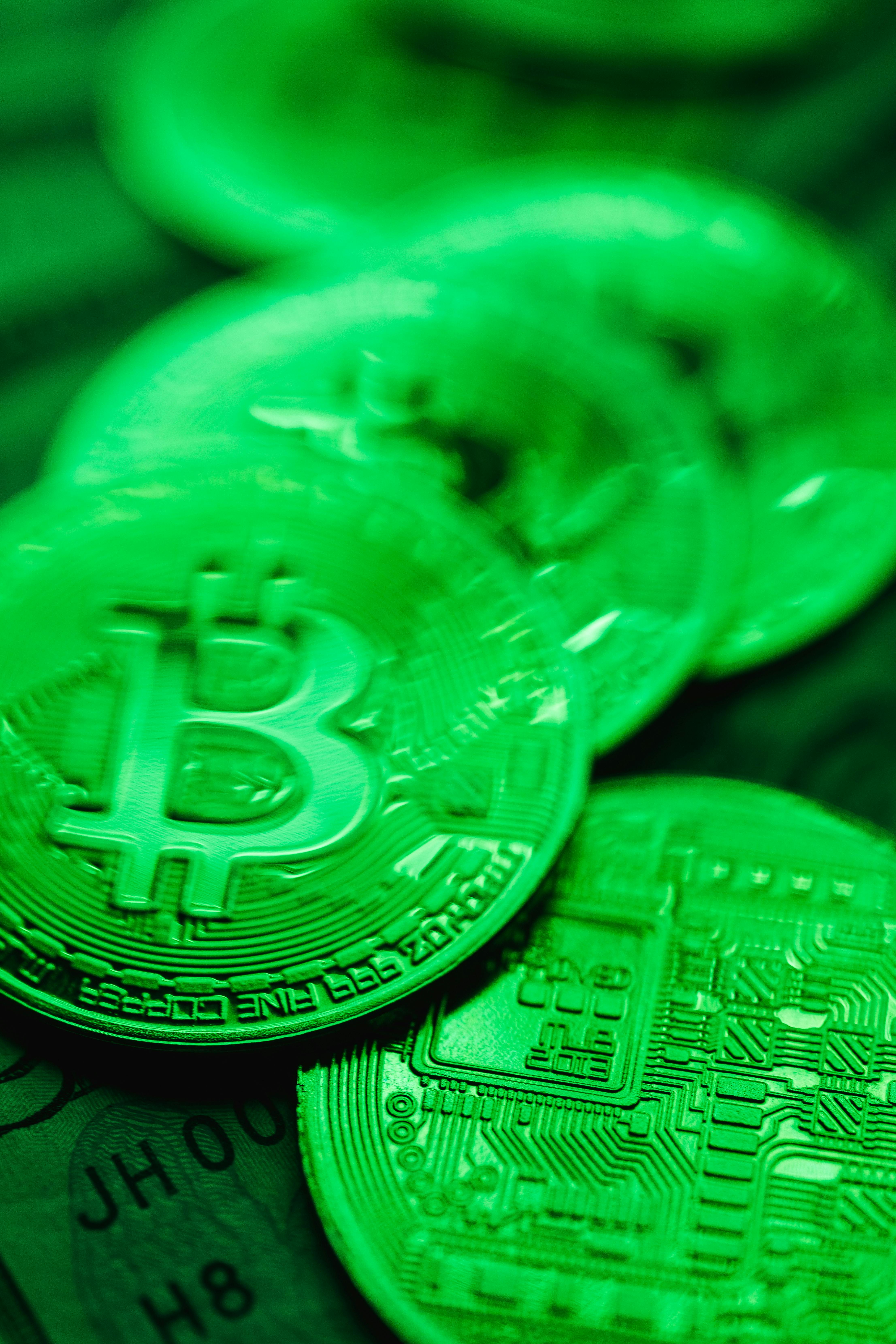 Bitcoins on Dollar Bills in Green Light · Free Stock Photo