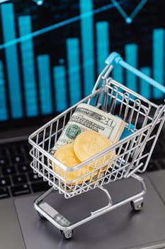 Shopping cart with US dollars and bitcoins on laptop, symbolizing online finance and investment.
