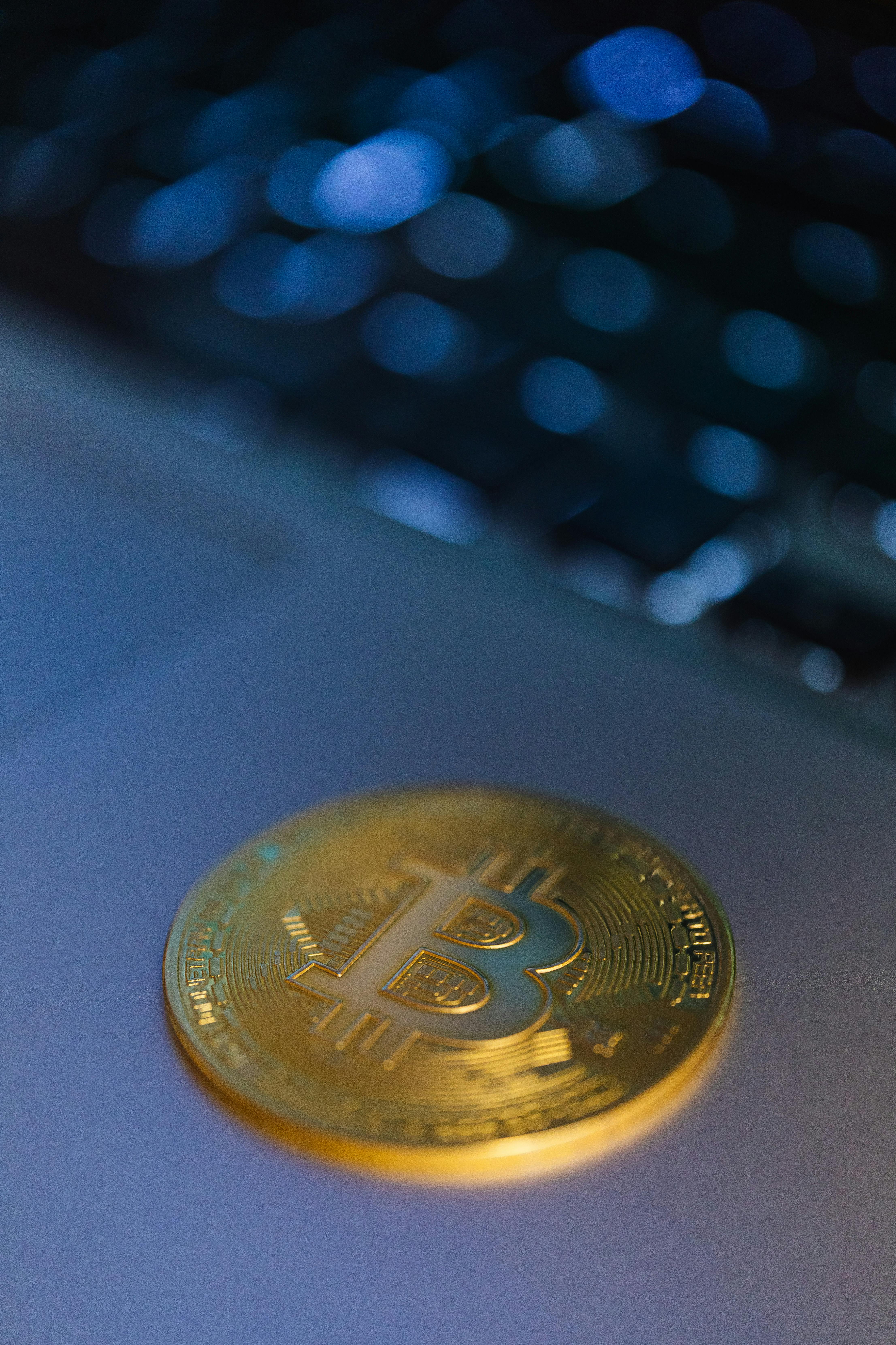 close up of a gold bitcoin coin lying on a laptop