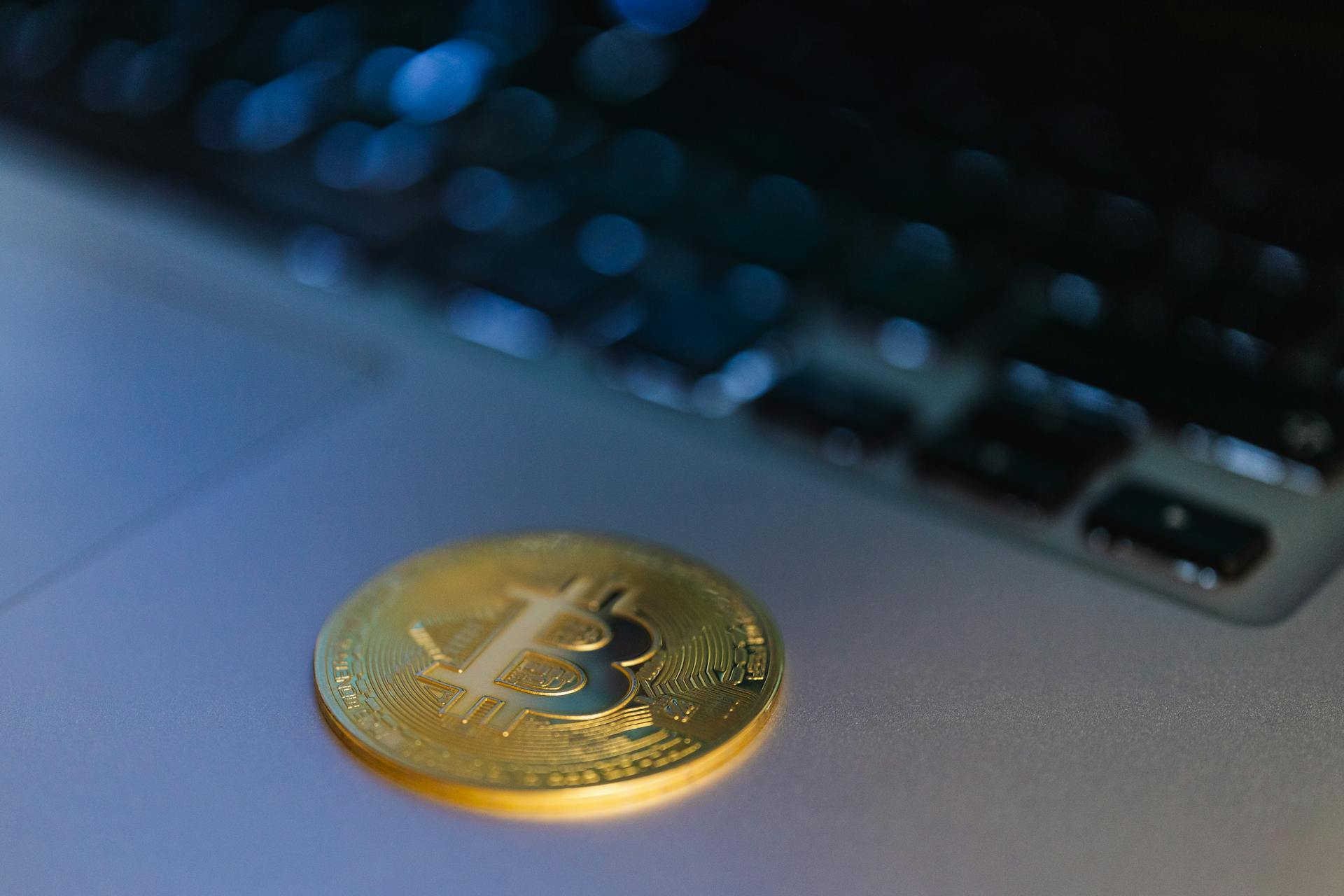 Close-up of a Bitcoin coin on a laptop, symbolizing digital currency and technology.