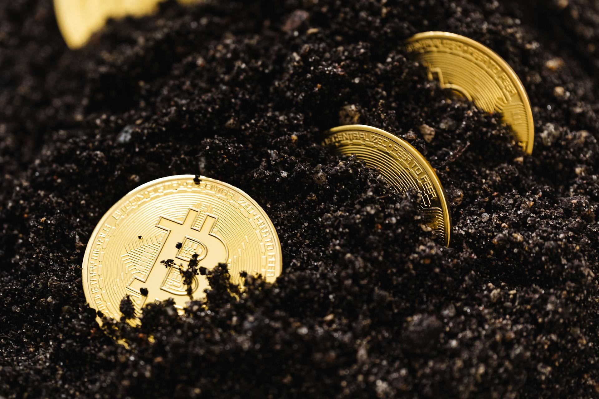 Close-Up Shot of Bitcoins Buried in the Ground