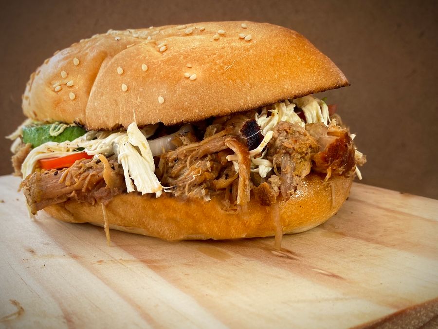 A pulled pork sandwich piled into a seeded bun