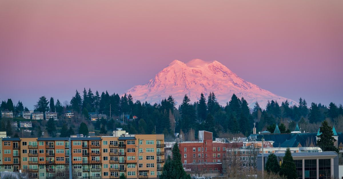 Breathtaking view of Olympia cityscape with Mount Rainier glowing at sunset.
