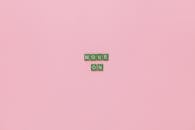 A Text Saying "Move On" Made from Tiles with Letters Lying on Pink Background