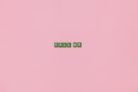 Green Scrabble Tiles in Pink Background