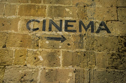 Writing on a Brick Wall Showing the Direction to a Cinema 