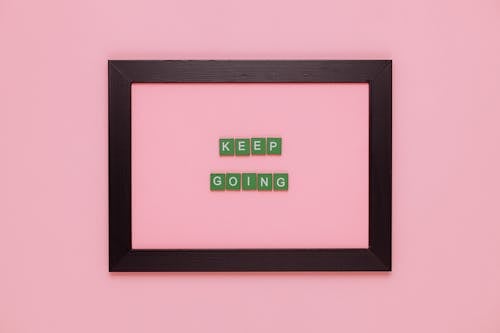 Free A Text Saying "Keep Going" in a Frame on Pink Background  Stock Photo