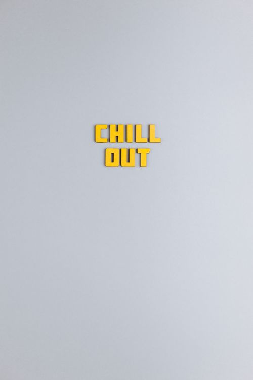 Free A minimalist image featuring yellow 'Chill Out' text on a gray background with copy space. Stock Photo