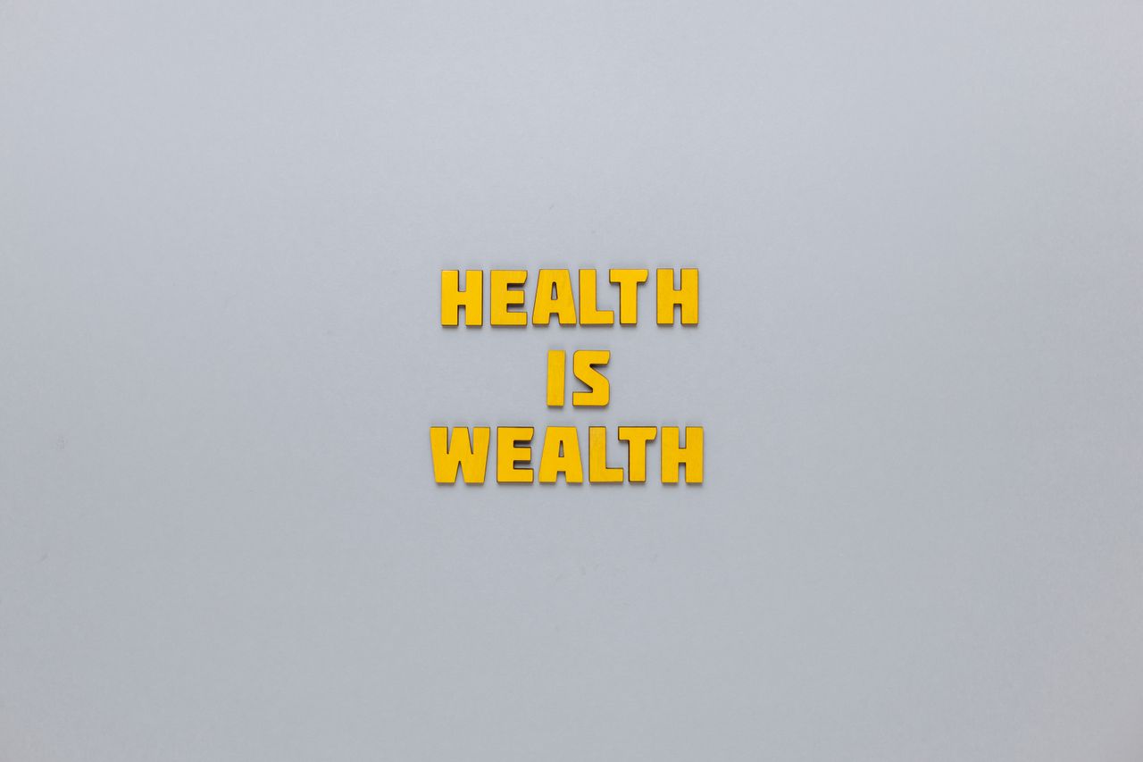 inspirational phrase health is wealth in bold yellow letters on a neut