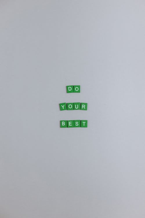Green Scrabble Tiles on a White Surface 
