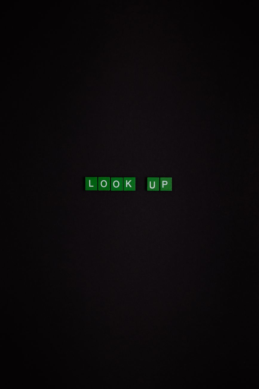 Green alphabet blocks forming 'Look Up' on a dark, minimalist background.