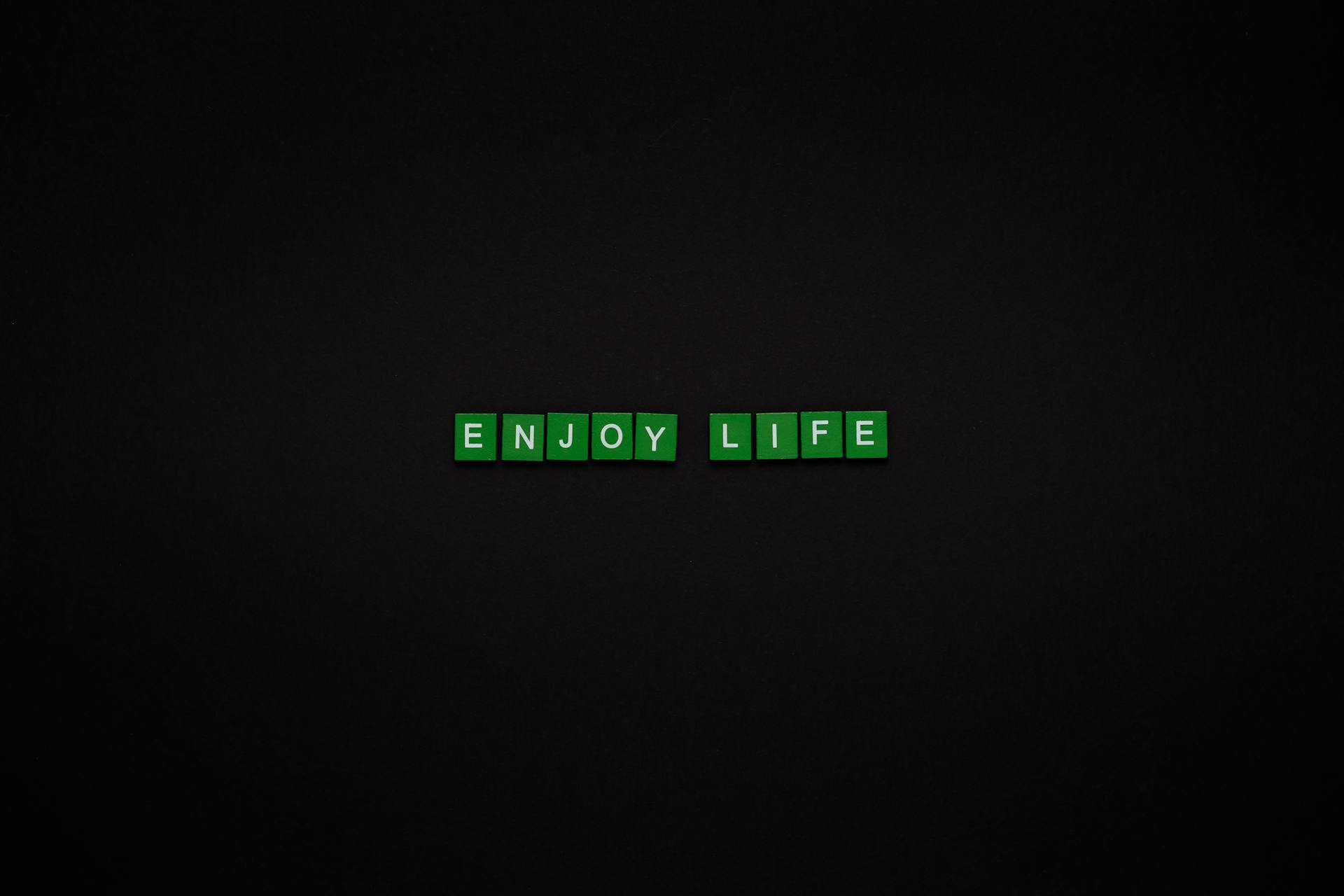 Enjoy Life Text On Green Tiles With Black Background