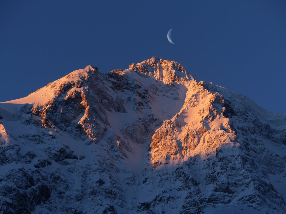 Free Crescent Moon over Snow Capped Mountain Stock Photo
