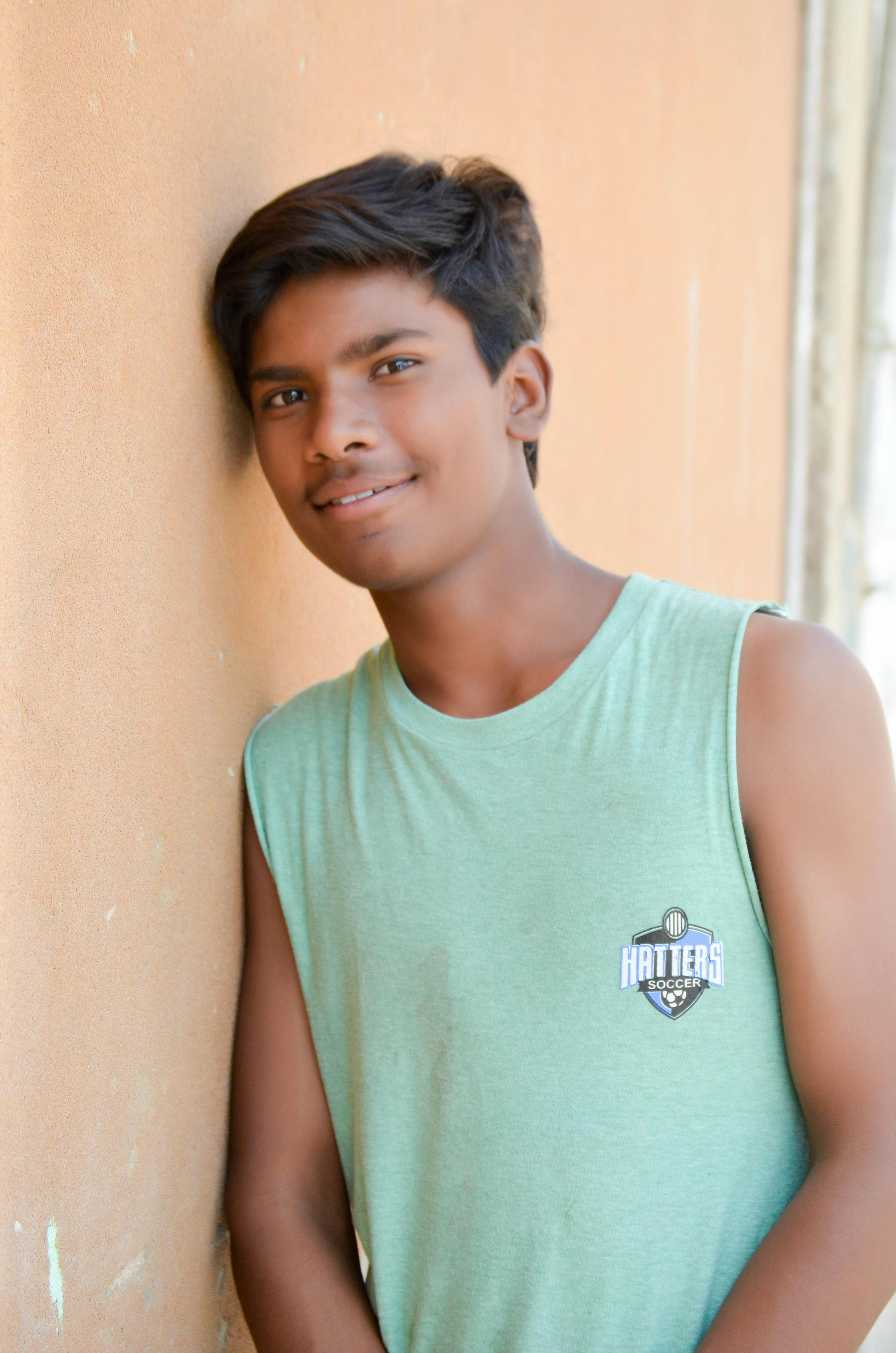 Portrait of a smiling teenage boy leaning against a wall, Karachi, Pakistan.