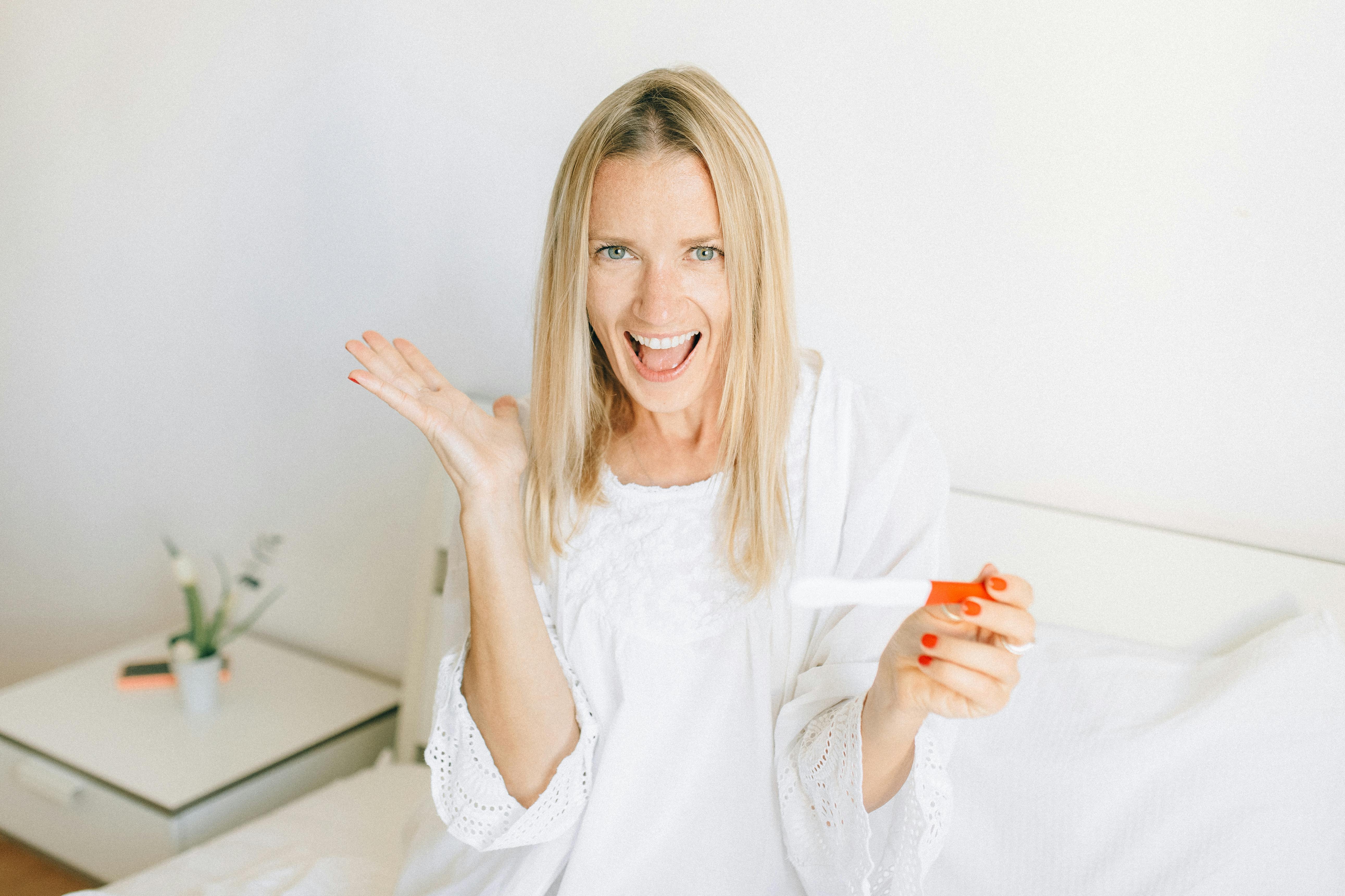 woman in white long sleeve shirt holding orange plastic cup