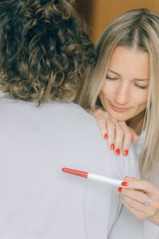 一位快乐的女子在室内与伴侣分享了怀孕的喜讯，两人度过了一段温馨的时光