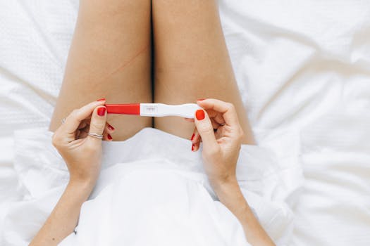 Woman in Red Manicure Sitting on White Textile