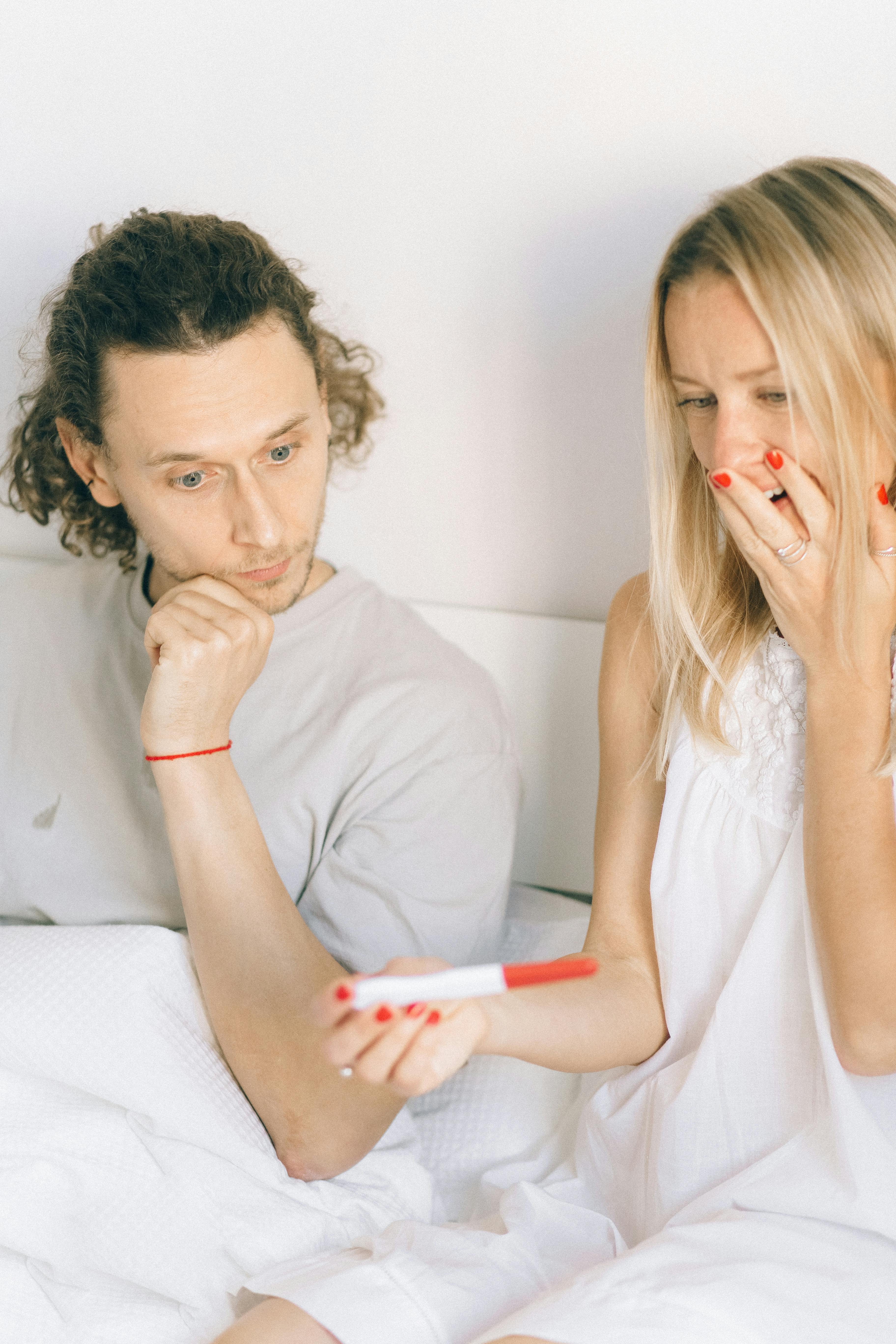 shocked couple looking at the result of pregnancy test