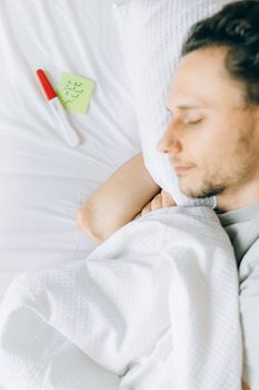 白人男子在床上安详地睡觉，旁边的妊娠测试呈阳性，便利贴也在一旁
