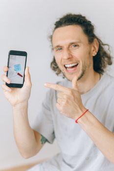 一个开朗的男人用纸条和笔在智能手机屏幕上表达幸福和沟通