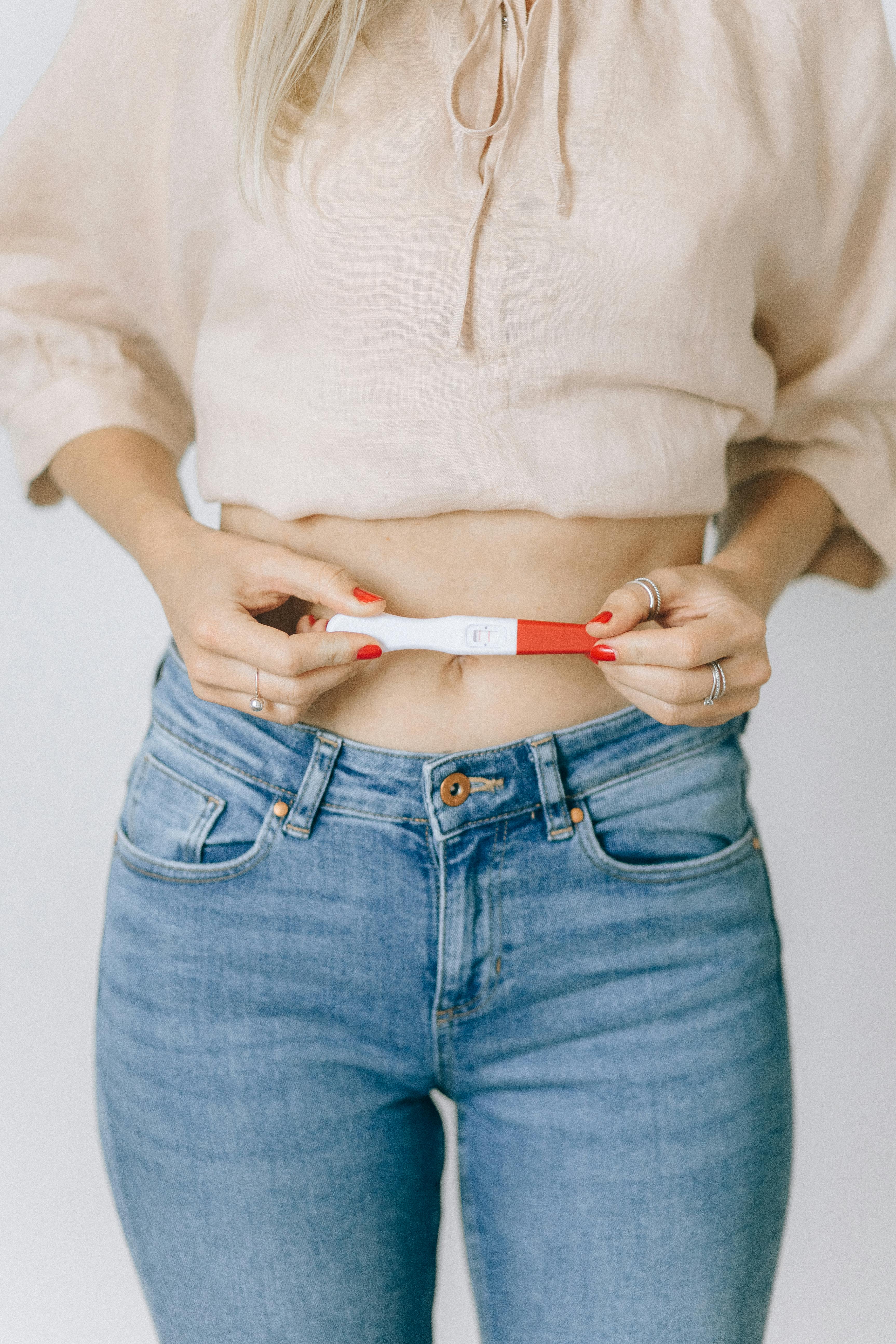 close up shot of a woman holding positive pregnancy test