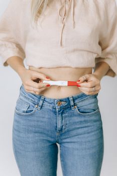一名手持验孕棒显示阳性的女性特写，捕捉了幸福的瞬间
