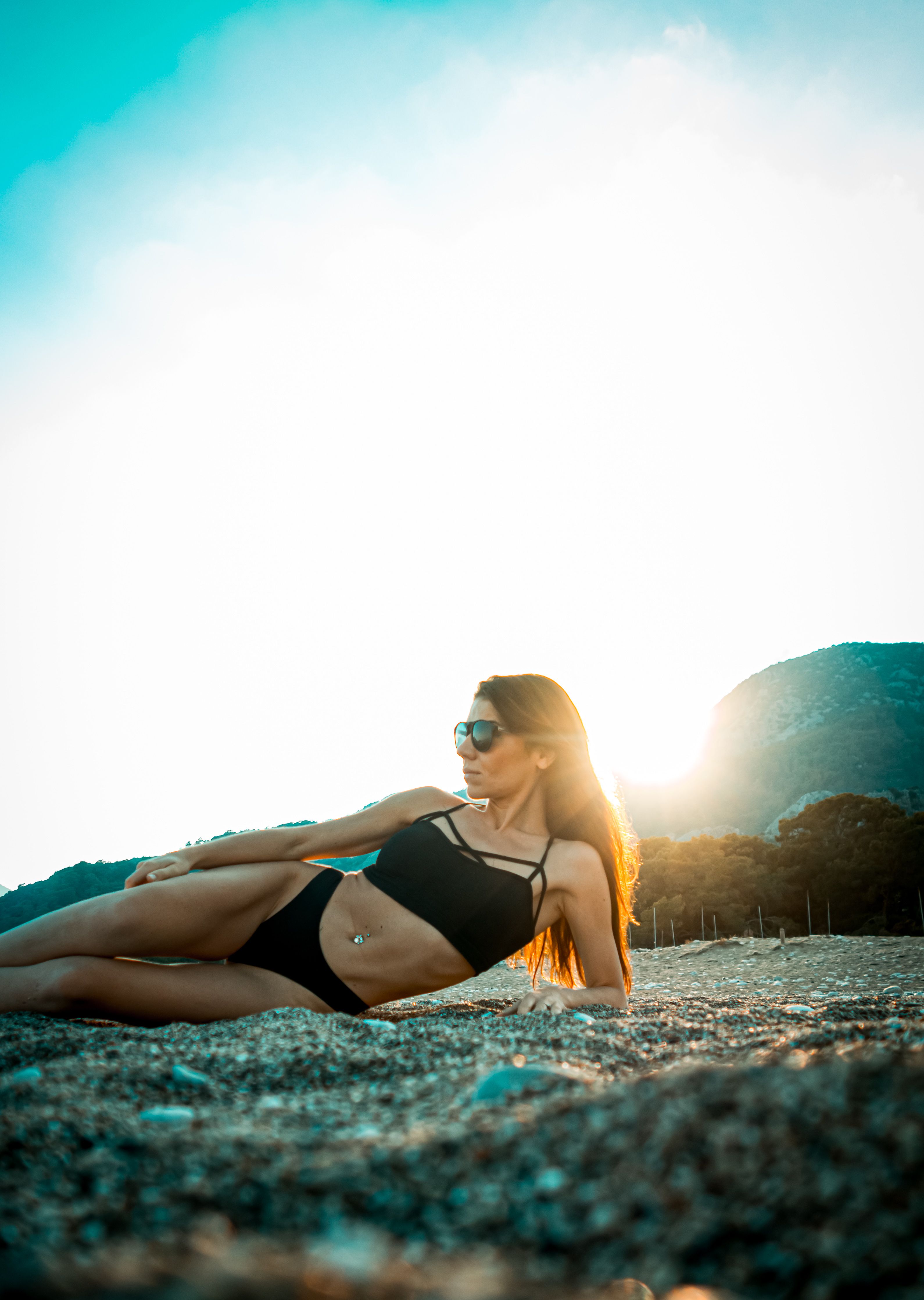 Woman in Black Bikini Lying on the Beach Sand · Free Stock Photo