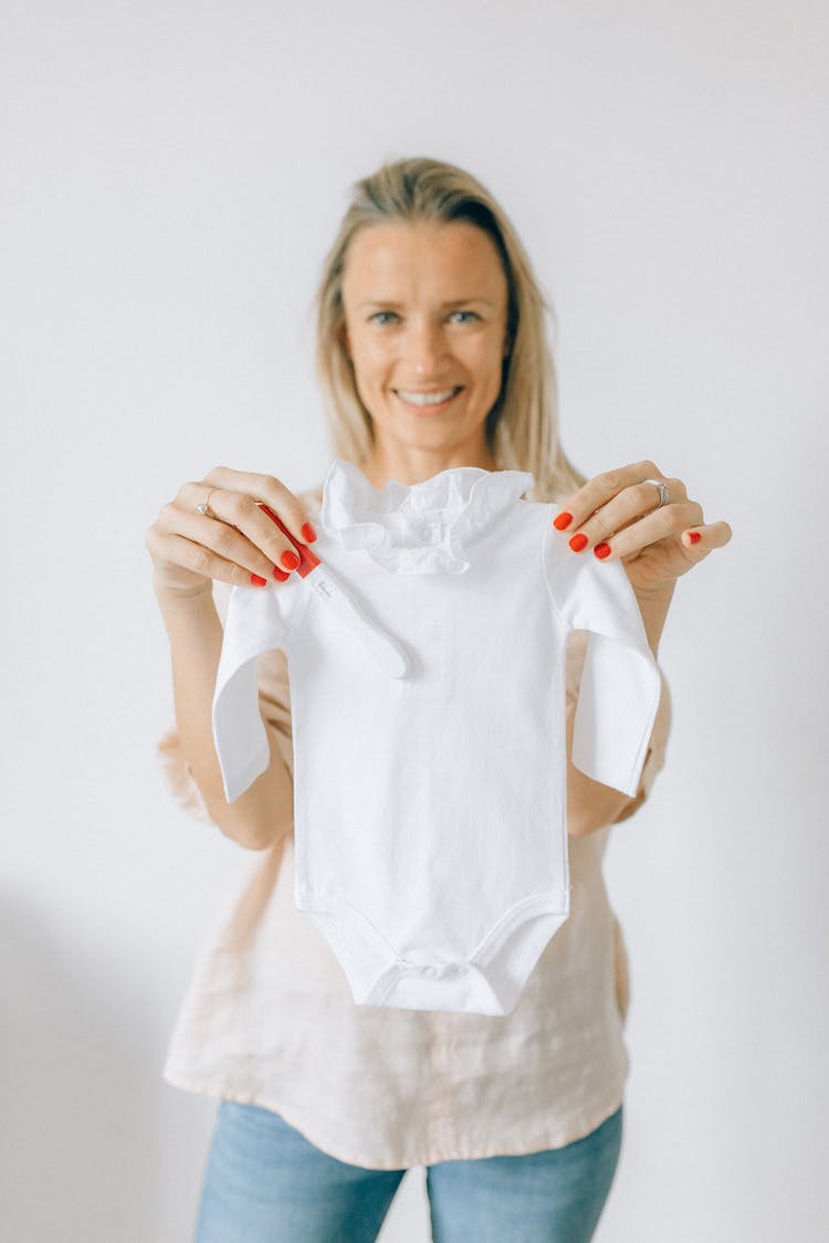 Woman Holding A White Baby Onesie