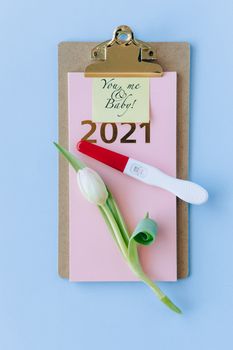 佩戴郁金香和蓝色背景的验孕棒，宣布2021年新产品问世