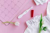 White and Red Toothbrush Beside White Textile