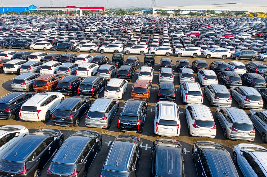 Free From above of rows with many modern new shiny automobiles of contemporary industry in daytime Stock Photo