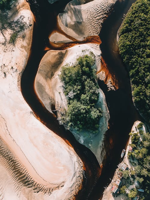 Brown river flowing through sandy coast in tropical resort