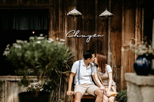 Kissing Asian couple sitting on bench