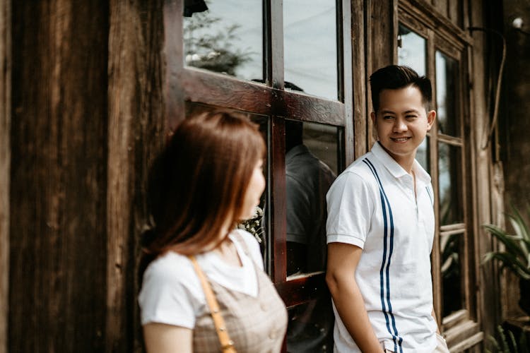 Happy Asian Couple Smiling At Each Other On Street